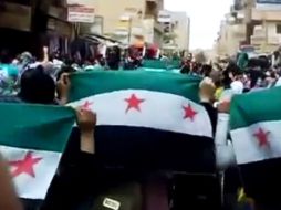 Los manifestantes salen a las calles con banderas sirias para continuar sus protestas contra el régimen. AP  /
