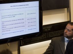 Un hombre mira el tablero electrónico que anuncia las cifras de la recuperación de YPF para el gobierno argentino. AP  /