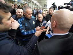 Mourinho atiende a algunos seguidores del Real Madrid a su llegada en el aeropuerto de Munich. EFE  /