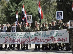 Soldados sirios gritando proclamas y sosteniendo fotografías del presidente Bachar Al Asad con banderas nacionales. EFE  /
