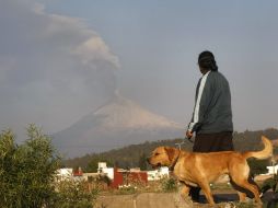 Un hombre y su perro osbservan una exhalación del volcán Popocatépetl. EFE  /