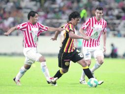 Édgar González, de la UdeG, conduce el balón ante la marca de la defensa necaxista.  /