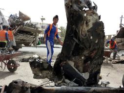 Operarios iraquíes limpian el lugar de una explosión. Varias bombas estallaron en Iraq y dejaron al menos 30 muertos. EFE  /