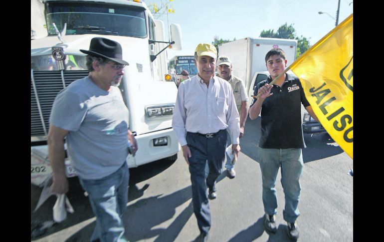 Garza (centro) saludó a automovilistas y peatones en la Zona Industrial y visitó a comerciantes del mercado de San Bernardo.  /