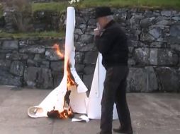 El artista John Brown quema una de sus creaciones en protesta, en video de YouTube. ESPECIAL  /