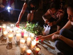 Familiares de las víctimas colocan velas en un altar improvisado en memoria de los fallecidos. AFP  /