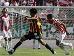 Édgar González, de Leones Negros, trata de avanzar ante la marca de un jugador de Necaxa. MEXSPORT  /