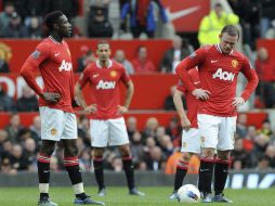 Rooney del Manchester United (d) y sus compañeros Ferdinand (c) y Welbeck (i) muestran su decepción tras resultado ante el Everton. EFE  /