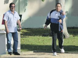 Hugo Chávez, quien aparece junto a su hermano Adán, intenta colocar una “bocha” o esfera. AP  /