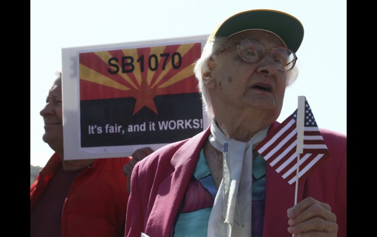 Manifestantes a favor de la SB 1070 sostienen pancartas afuera de la Suprema Corte. REUTERS  /