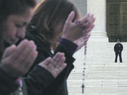 Personas rezan afuera del Tribunal Supremo donde discuten la aplicación de la ley migratoria en Arizona. AFP  /