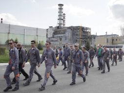 Trabajadores de la construcción que montarán el sarcófago caminan por la inmediaciones de Chernobyl.  AP  /