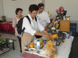 Una familia deposita flores sobre el cadáver de Bisho, un perro Golden Retriever, en su funeral en el templo That Thong. EFE  /