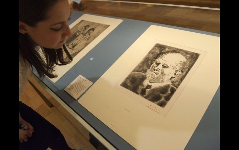 Una mujer observa un aguatinta de Picasso, representando a Ambroise Vollard. AFP  /