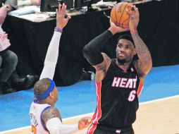LeBron James (6) dispara a la canasta ante la marcación de Carmelo Anthony. AFP  /