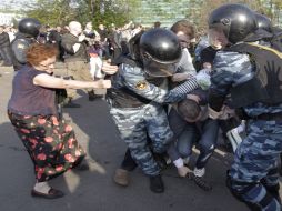 Miembros de las fuerzas antidisturbios detienen a uno de los opositores de Vladimir Putin que protestaron en plaza Bolótnay. EFE  /