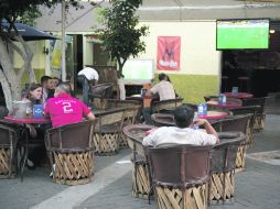 Asistentes a los bares en Zapopan observan el encuentro entre Tigres y Monarcas, mientras se desarrollaba el debate presidencial.  /
