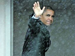 Barack Obama saluda antes de abordar el helicóptero Marine One, en el Aeropuerto Internacional de Albany, en Colonie, Nueva York. AP  /
