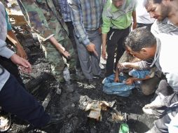 Expertos recogen pruebas en el escenario del doble atentado perpetrado en la zona de Qazaz. EFE  /