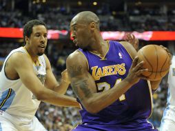 El jugador de Los Ángeles Lakers, Kobe Bryant, intenta esquivar a Andre Miller (i) y Ty Lawson (d) de los Denver Nuggets. EFE  /