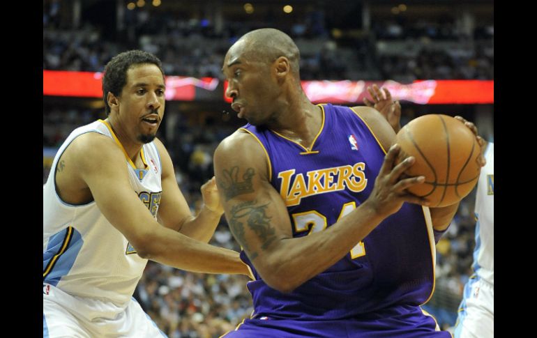 El jugador de Los Ángeles Lakers, Kobe Bryant, intenta esquivar a Andre Miller (i) y Ty Lawson (d) de los Denver Nuggets. EFE  /