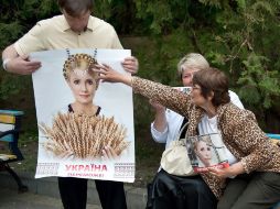 Seguidores de Timoshenko sostienen carteles con sus retratos cerca del hospital donde la polítca es atentida. EFE  /