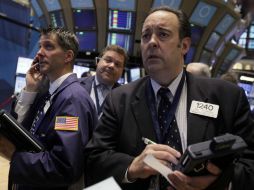 Robert Maher (D) trabaja con otros operadores en el piso de la Bolsa de Nueva York. AP  /