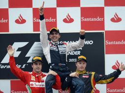 Pastor Maldonado es alzado en hombros de Alonso y Raikkonen. AFP  /