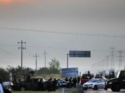 Forenses que investigan el caso son resguardados por militares y policías federales. EFE  /