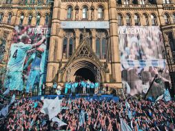 Aficionados y jugadores del Manchester City celebran a las afueras del ayuntamiento de la ciudad. AP  /