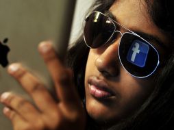 El logo de Facebook se refleja en los lentes de una de sus 900 millones de usuarios. AFP  /