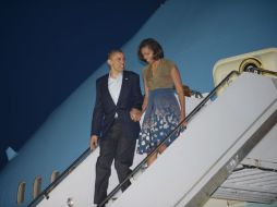 Barack Obama y la primera dama Michelle Obama bajan del avión en el aeropuerto de Chicago. EFE  /