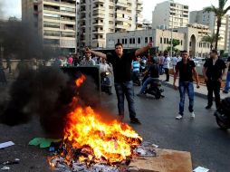 Un grupo de libaneses chiíes incendian un contenedor en Beirut. EFE  /