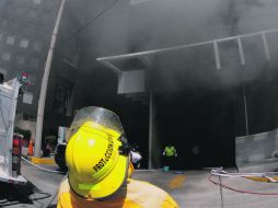 Un elemento de Protección Civil observa las maniobras de un helicóptero en el  rescate de personas atrapadas en el inmueble. EFE  /