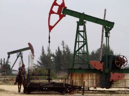 Alfonso Arias, monta su caballo junto a una bomba de aceite operado por la empresa estatal Petróleos Cuba, Cupet, en Santa Cruz del Nor  /