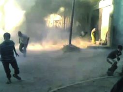 MOMENTOS DE HORROR.- La imagen muestra a dos niños y un adulto que huyen de los ataques. Al fondo se aprecian humo y destrucción. AP  /