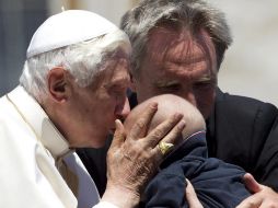 El Papa Benedicto XVI besa a un bebé durante la audiencia general semanal en la Plaza de San Pedro. EFE  /