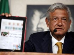 López Obrador muestra en un iPad una encuesta que coloca sólo cuatro puntos debajo del puntero, Peña Nieto, del PRI.  NOTIMEX  /