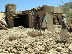 Afganos inspeccionan el lugar tras un ataque aéreo de la OTAN; siete rebeldes y 18 civiles murieron en el ataque de dos casas. EFE  /