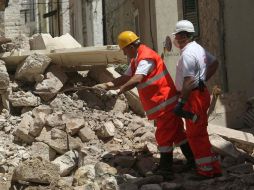 Bomberos italianos buscan entre los escombros tras el derrumbe. AFP  /