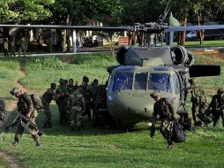 Soldados colombianos transportando armamento decomisado y los cuerpos de guerrilleros de las FARC. EFE  /