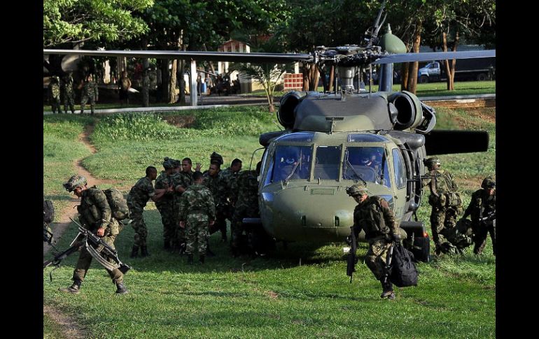 Soldados colombianos transportando armamento decomisado y los cuerpos de guerrilleros de las FARC. EFE  /