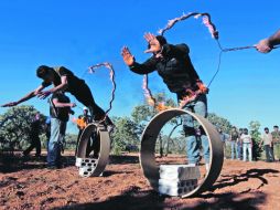 Miembros de Ejército Libre de Siria, saltan a través de un aro de fuego, durante un entrenamiento militar. AP  /