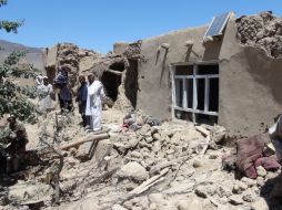 Aldeanos afganos se reúnen cerca de una casa destruida en un aparente ataque . ARCHIVO  /
