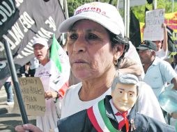 Cientos de simpatizantes del candidato de las izquierdas limpiaron la imagen de López Obrador, ayer en el Zócalo capitalino. EFE  /