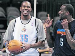 ÁNIMO POR LAS NUBES. Kevin Durant (i) y Kendrick Perkins  bromean, durante la práctica del Thunder. AP  /