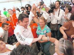 Varias mujeres mayores buscan una fotografía al lado del candidato del PRI a la gubernatura. ESPECIAL  /