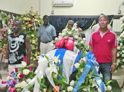 La gente, amigos y familiares le hicieron guardia al féretro del ex púgil cubano antes de su entierro este martes. AFP  /