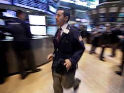 Un comerciante se apresura a través del piso de la Bolsa de Nueva York. AP  /