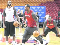 LeBron James intercambia ideas con Ronny Turiaf (camisa blanca) y Dwyane Wade, durante la práctica del Heat en su arena.REUTERS  /